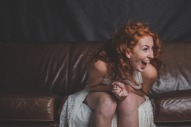 Un'immagine di una donna che ride, catturata in un momento di autentica gioia e divertimento, mentre la sua espressione riflette felicità e spensieratezza.