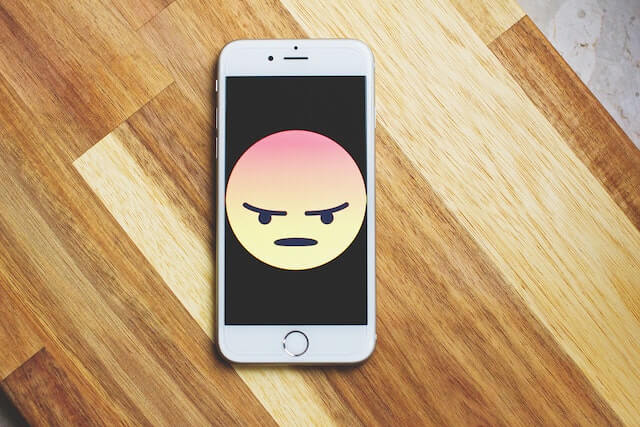 L'immagine di un'emoji arrabbiata visualizzata sullo schermo di un telefono.